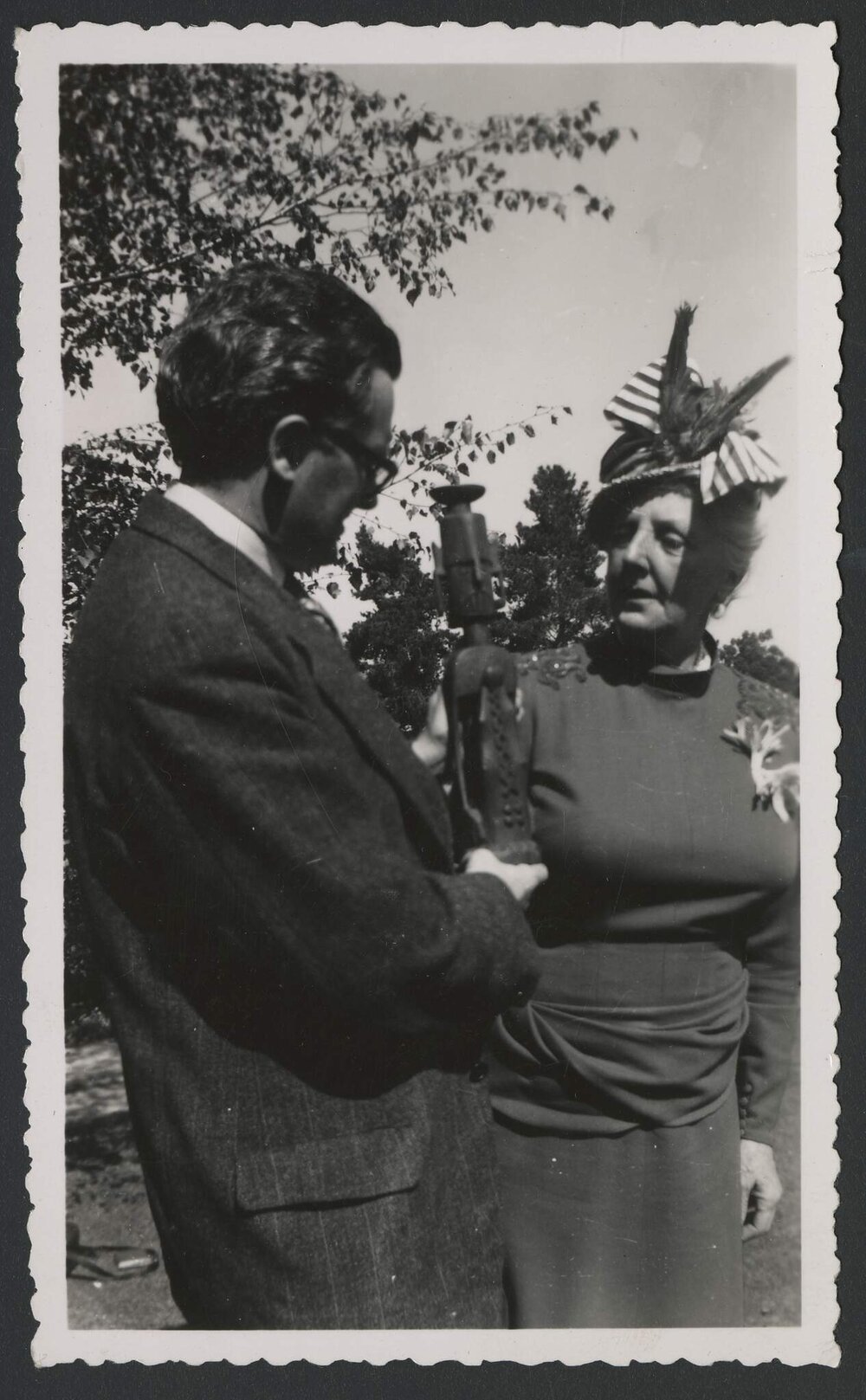 Jeff Hanson and Louise Hanson-Dyer standing outside holding and inspecting a small sculpture