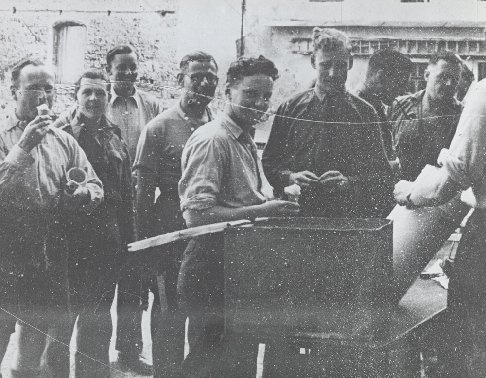 Unidentified prisoners of war camp: Group of men eating ice-cream.
