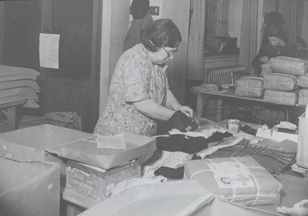 Red Cross workers wrapping clothes parcels