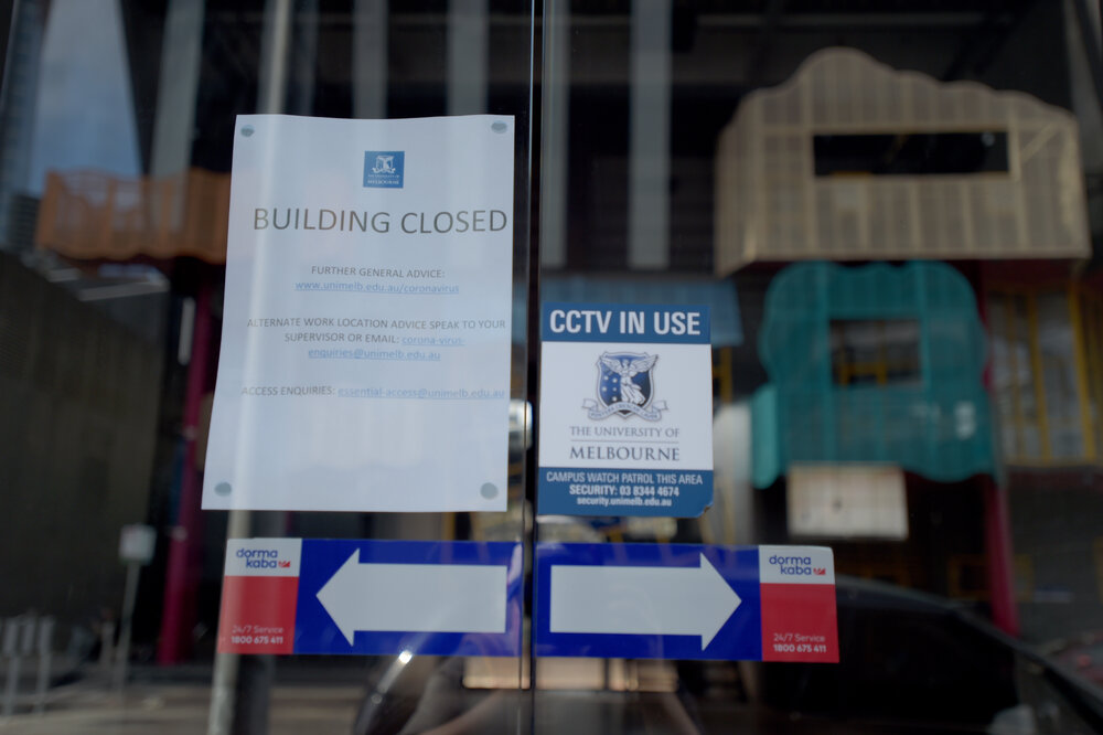 Southbank Campus during COVID lockdown - Building closure information signage with Performing Arts Dodds Street Building reflected in doors