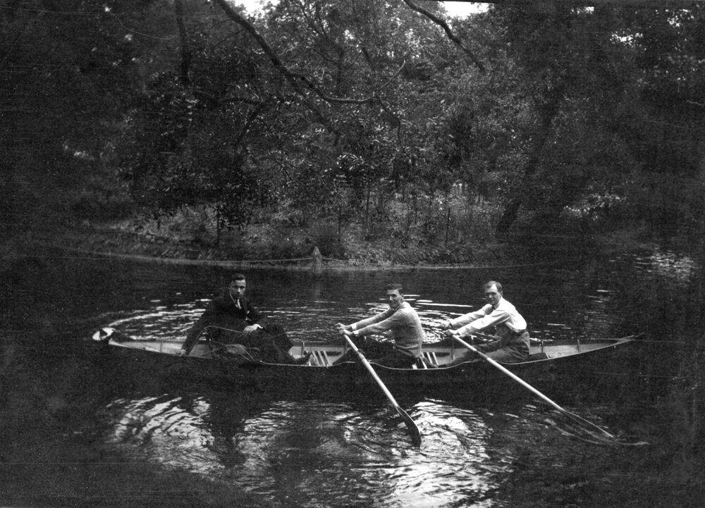 Three unidentified men in a row boat at an unknown location in London, England