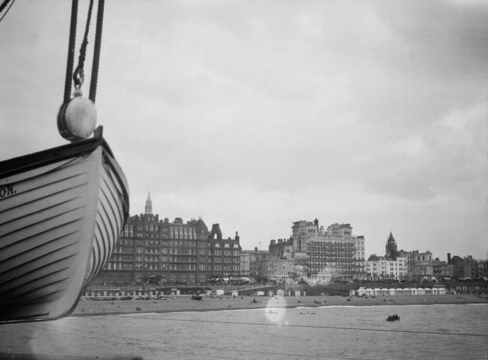 A scene of Brighton, England showing the beach front and buildings behind