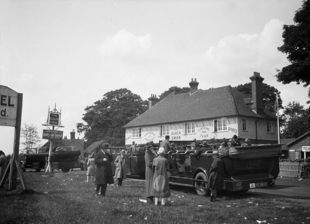 People gathered around an open passenger motor vehicle, outside the Black Swan Hotel at Brighton, England