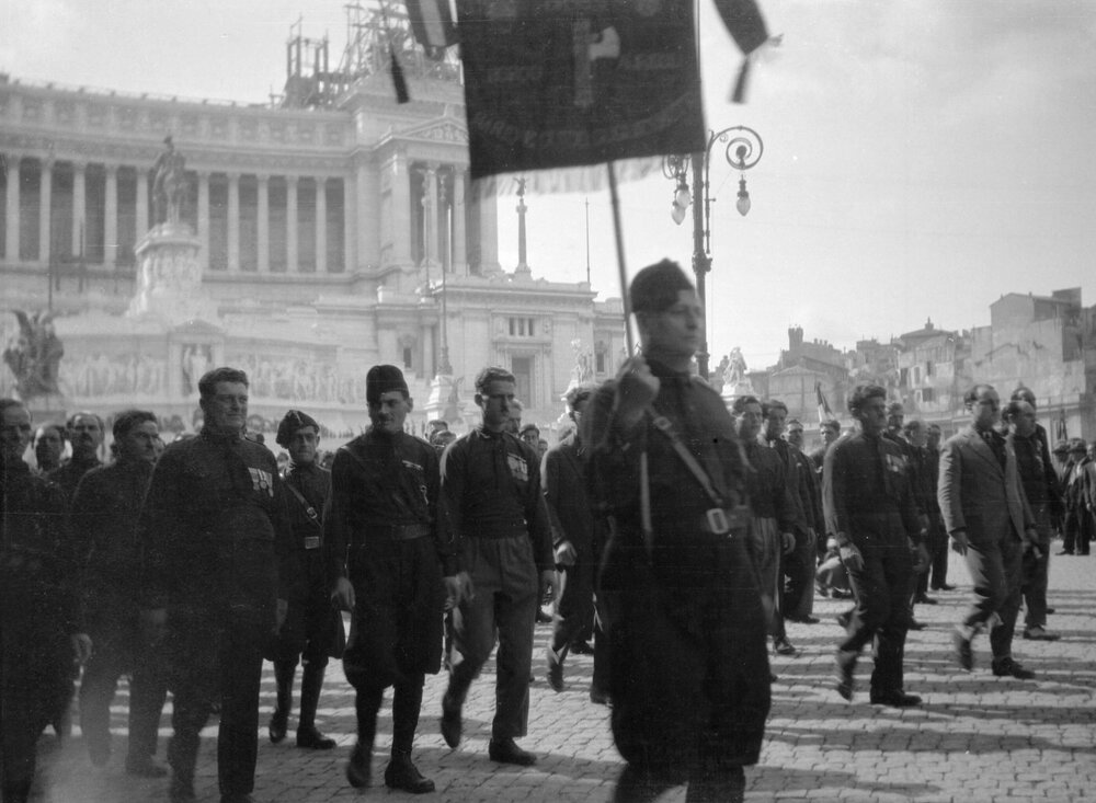 Men in military style uniforms parading in front of the Monumento Nazionale a Vittorio Emanuele II, Rome, Italy