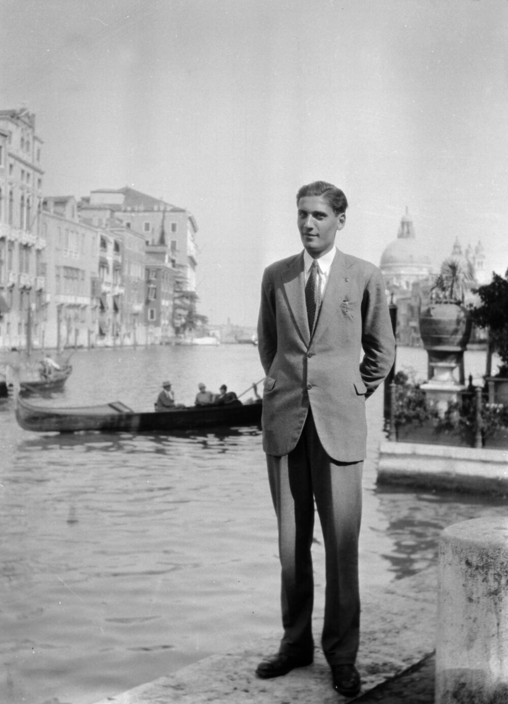 An unidentified man standing on the edge of a canal in Venice, Italy