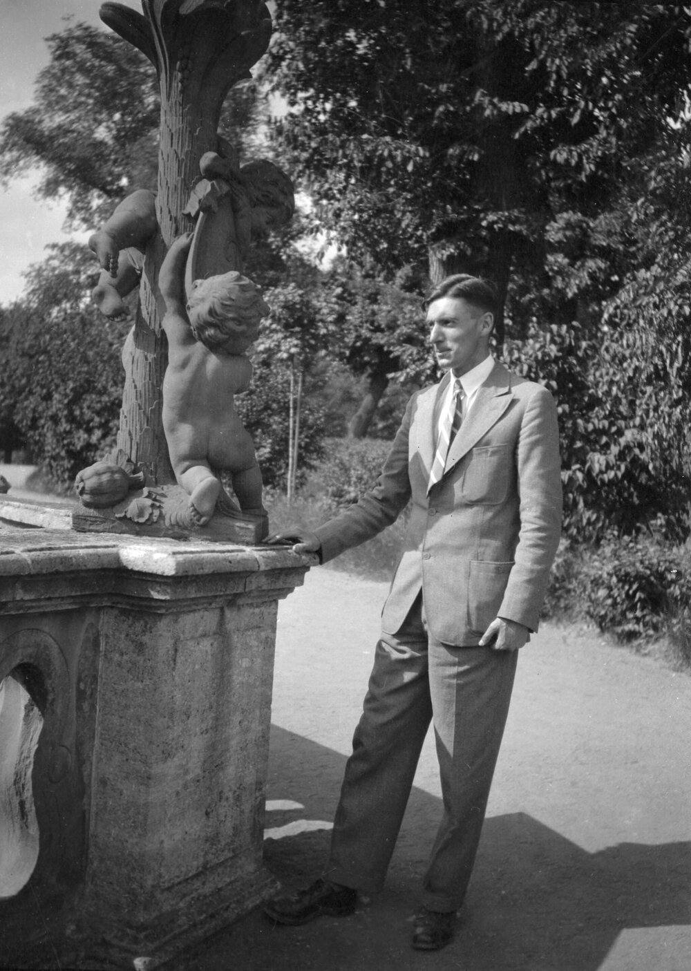 An unidentified man standing alongside a sculpture in or near Rothenburg, Dinkelsbuhl or Wurzburg, Bavaria, Germany