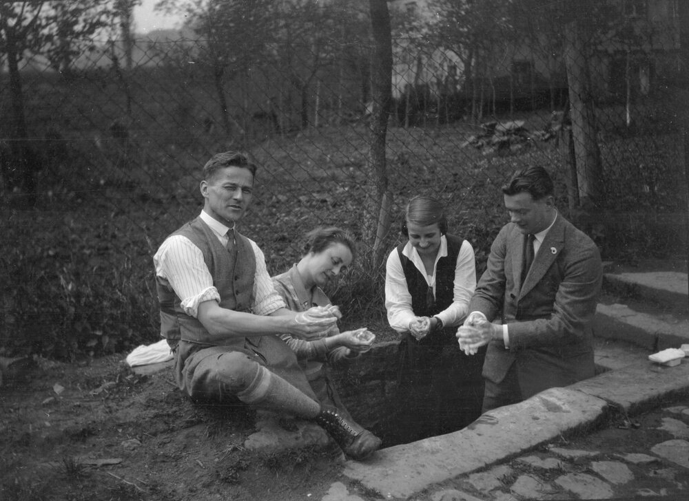 Two women and two men involved in hand washing, in either Palatinate - a region of south-west Germany, or Maulbronn - a city in southern German