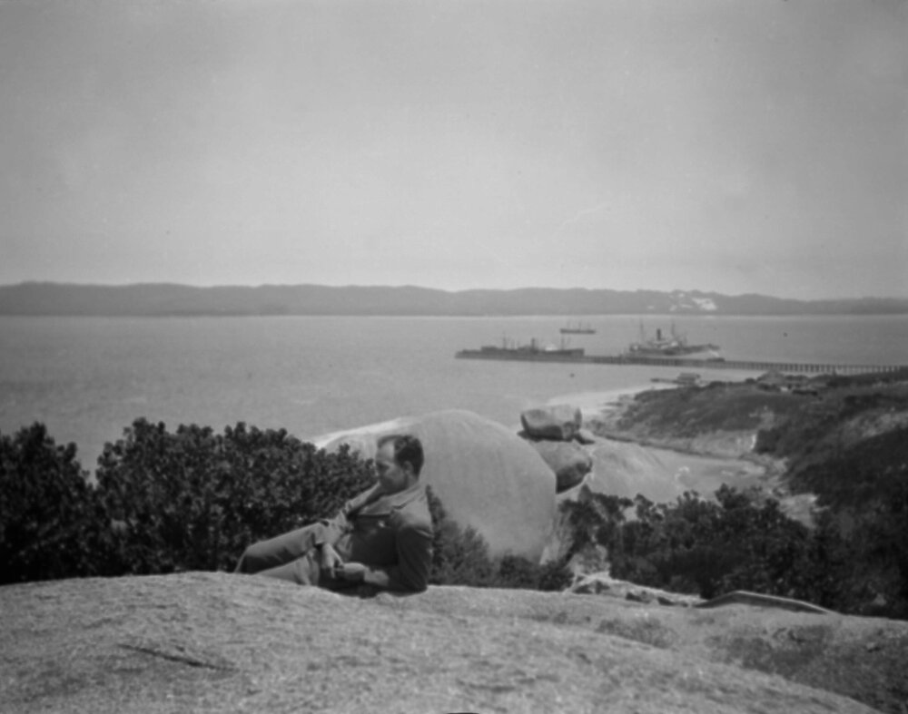 An unidentified man in the foreground of a coastal scene, probably near Albany (Western Australia) in February 1930