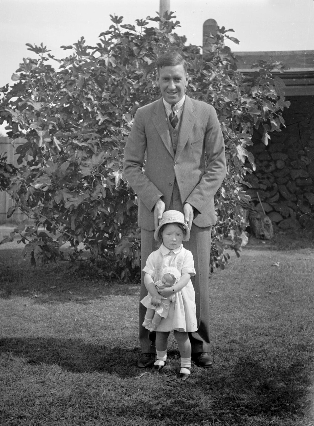 A man and a small girl holding a doll
