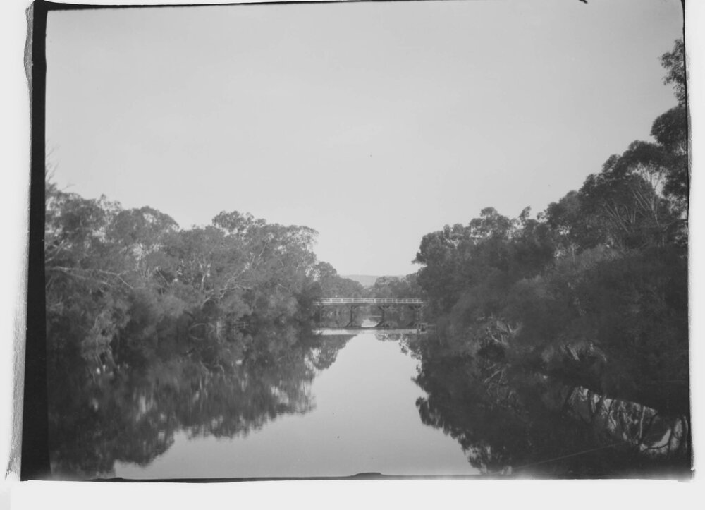 An unidentified river and timber bridge in an unknown bushland setting