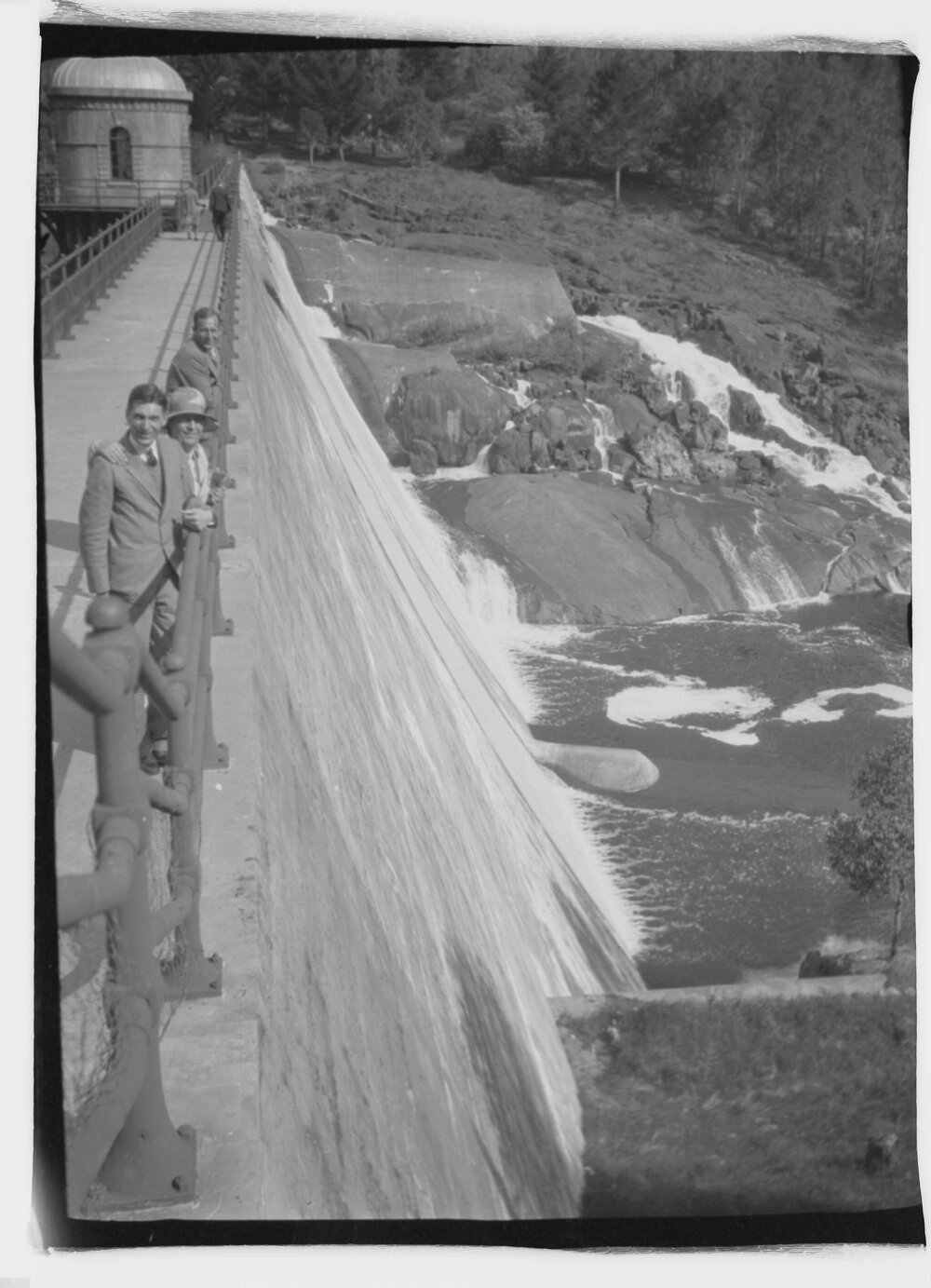 An unidentified group of two men and a woman on the retaining wall of  Mundaring Weir, west of Perth, Western Australia