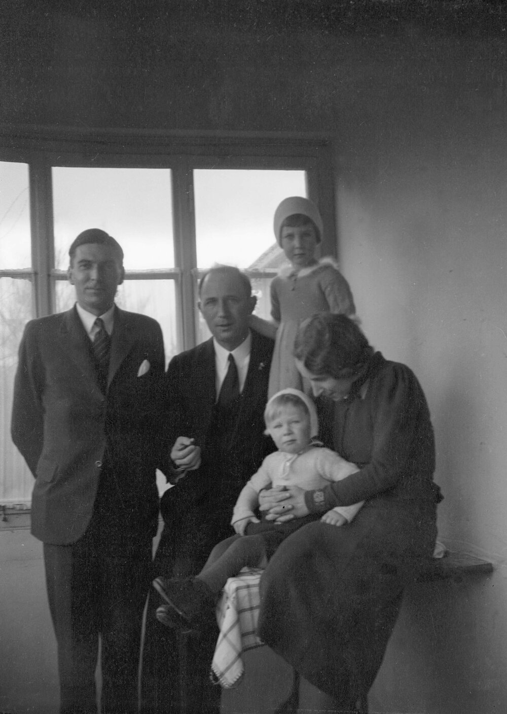 An unidentified group of a woman, two men and  two children posed inside a building