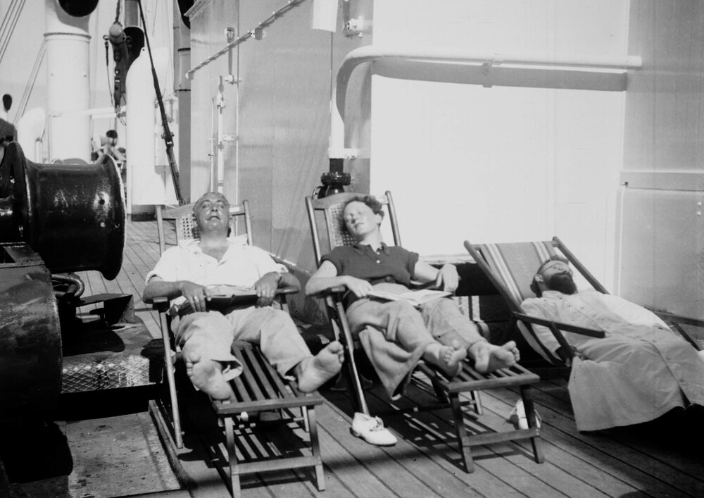 Three unidentified people asleep on deck chairs on a ship, possibly the S/S Aller during a voyage in December 1936 and January 1937
