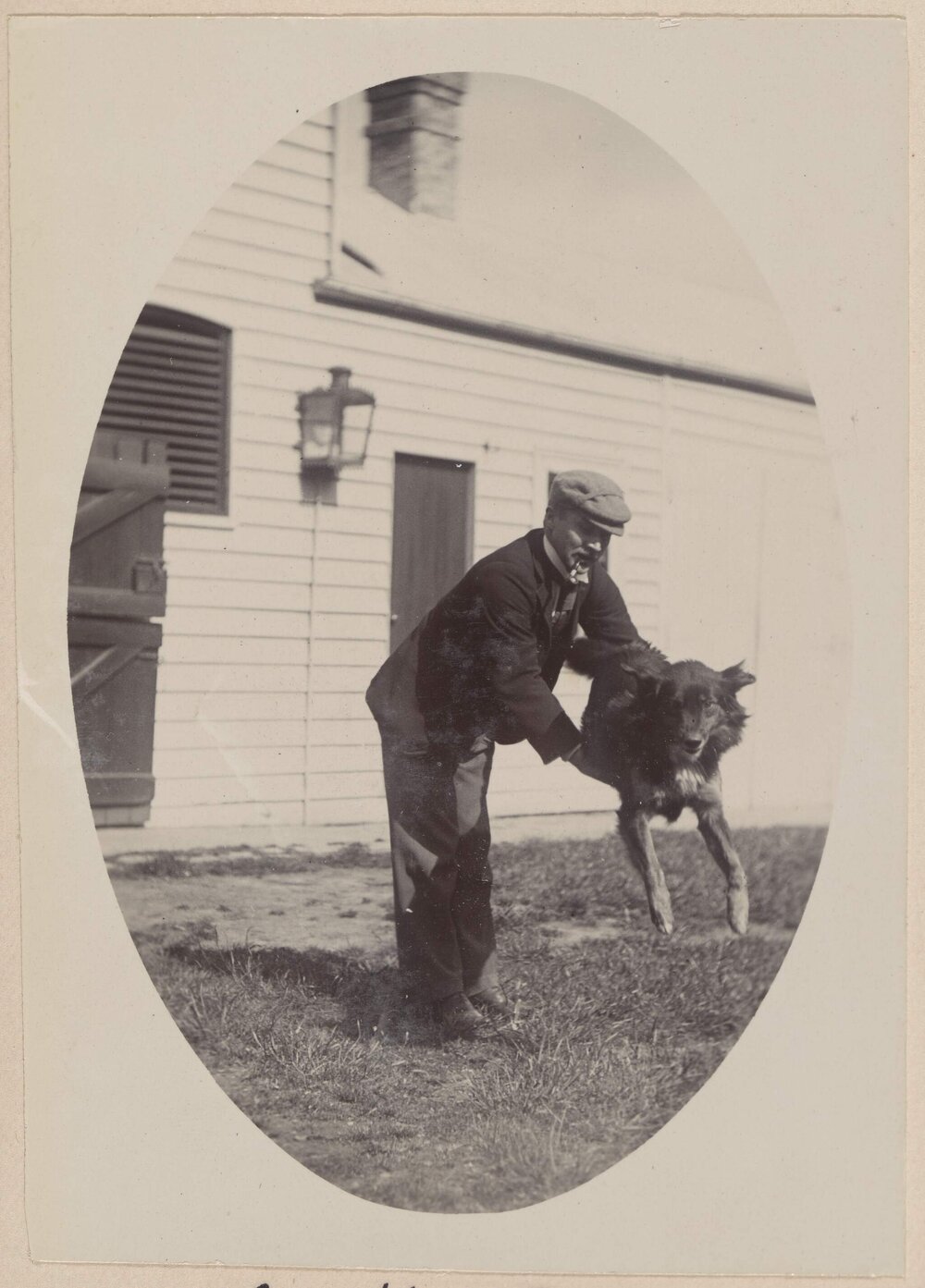 [Man holding black dog]