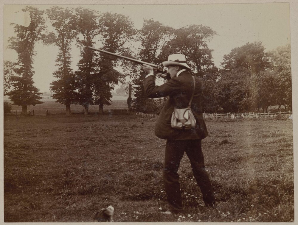 [Man wearing hat firing rifle]
