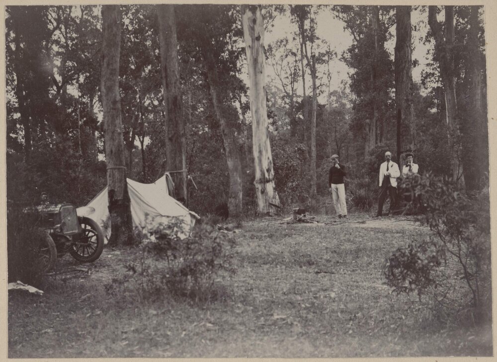[Two men and a woman at a campsite]