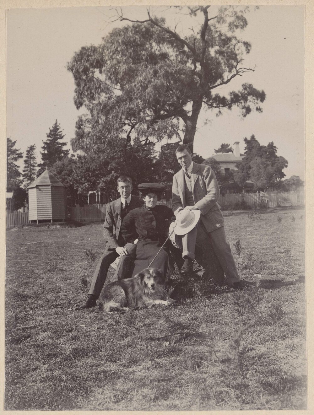 [Two men and woman posed with dog]