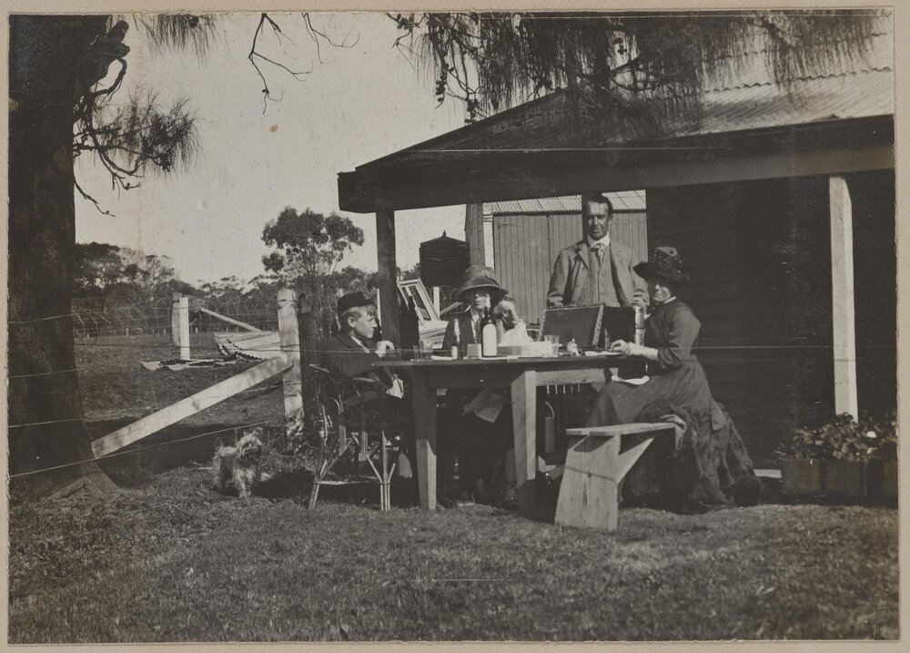 [Group eating at table outside, Marathon]