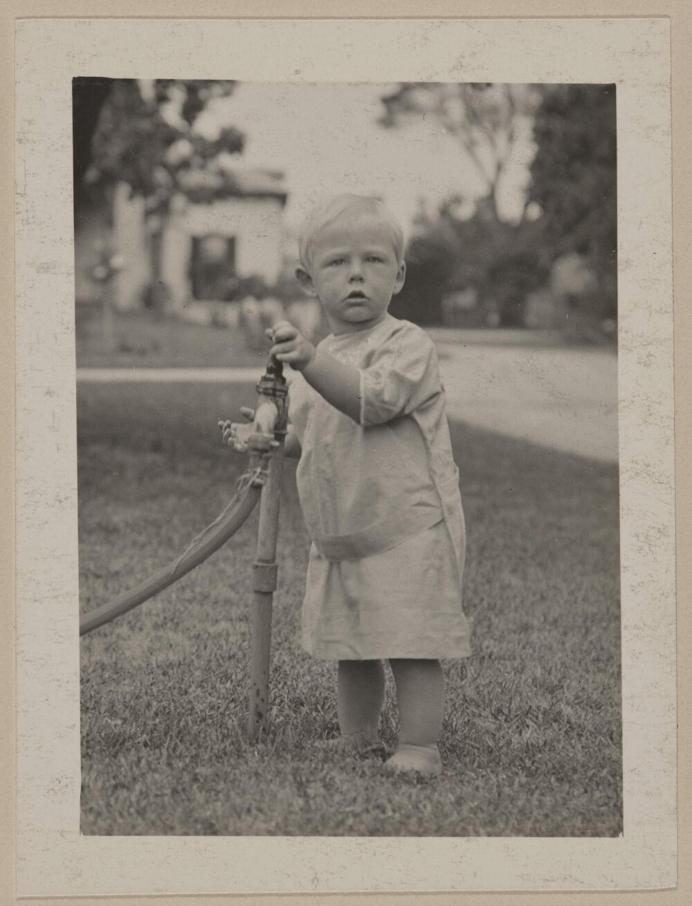 [Small boy playing with garden tap]