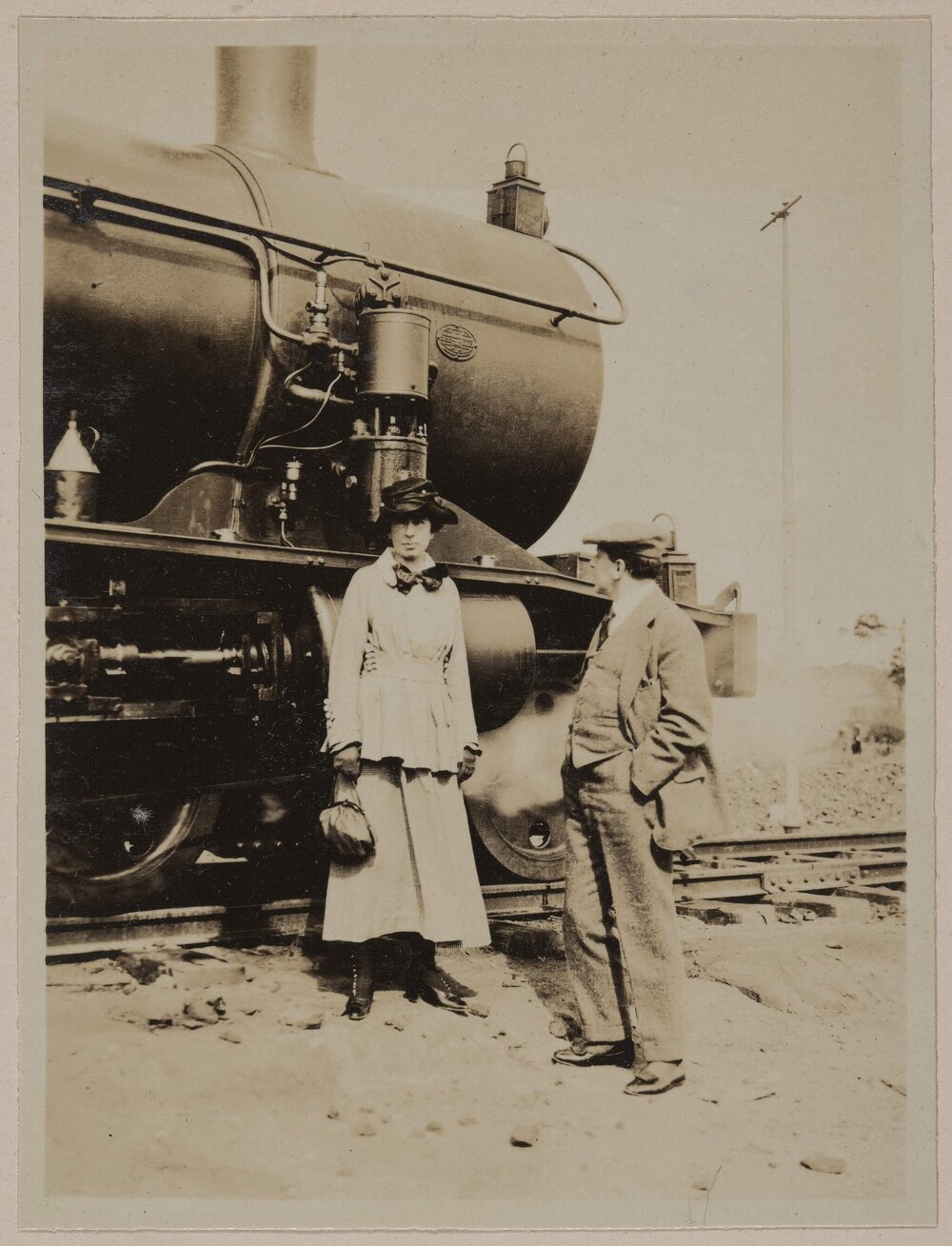 At Barton, South Australia [woman and man posed in front of locomotive]