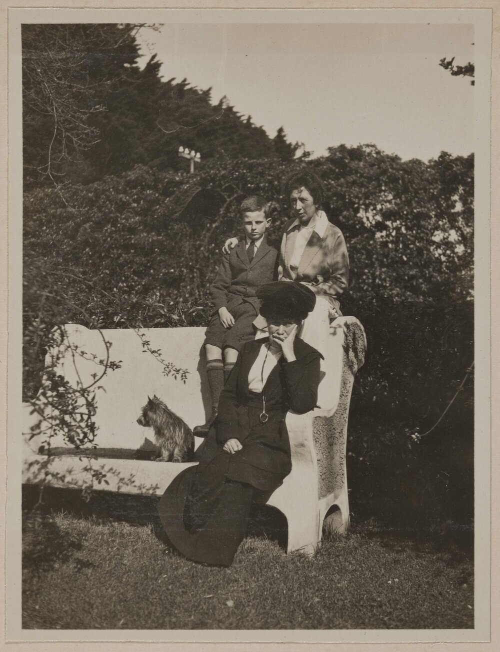 [Mabel Grimwade, woman, young boy and dog posed on garden bench]