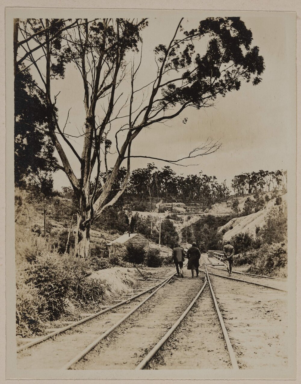 [Three men walking on railway tracks]