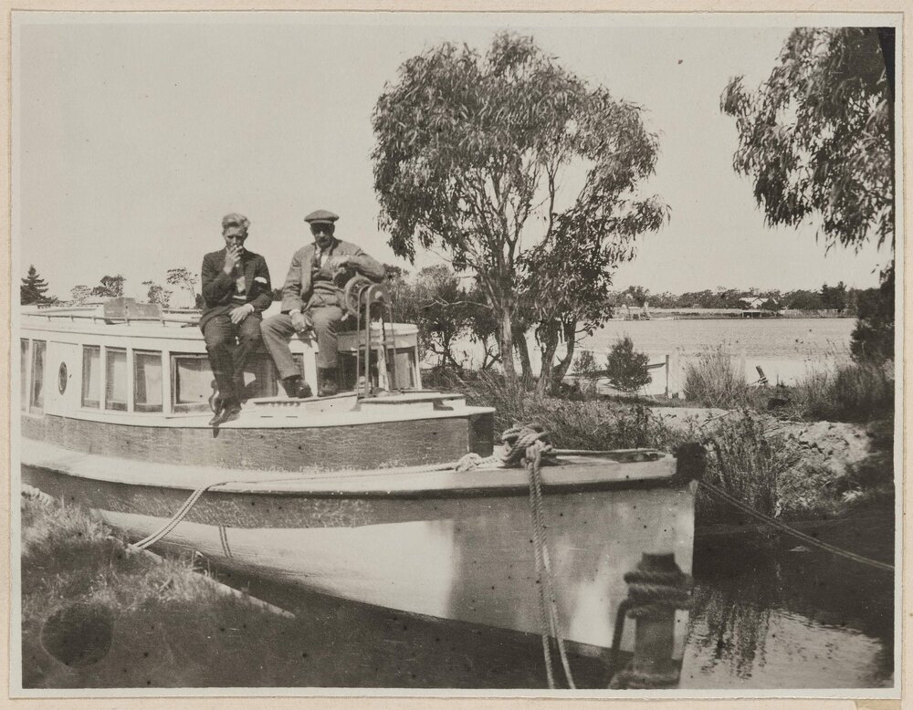 [Two men sitting on boat]