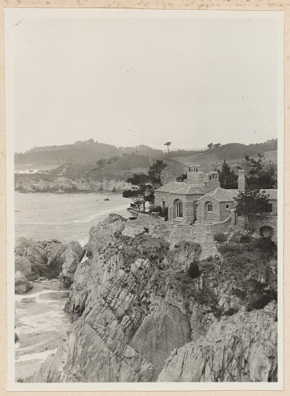 [View of large building on cliff overlooking ocean]