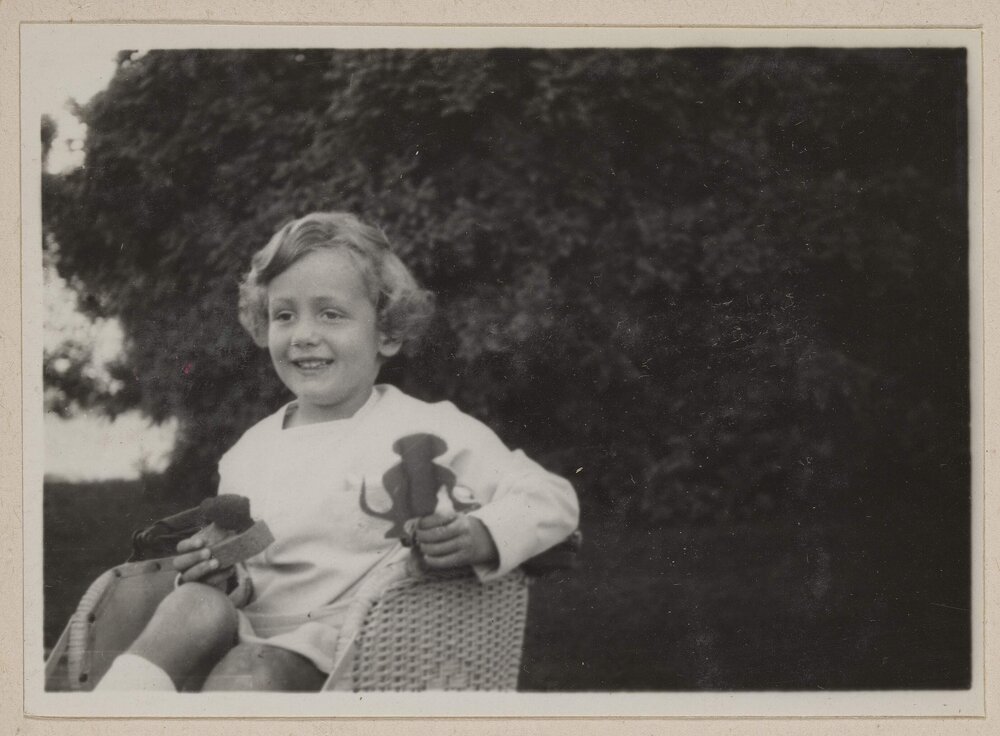 [Smiling child holding bird figurine at Miegunyah]