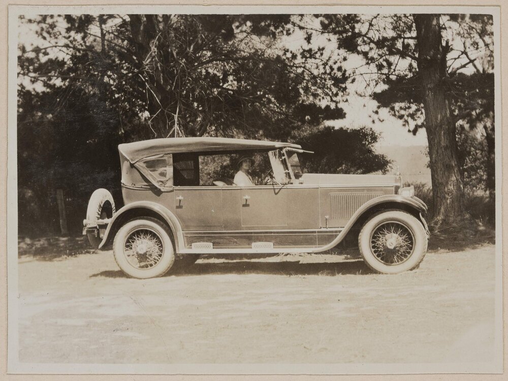 [Woman in front seat of motor car]