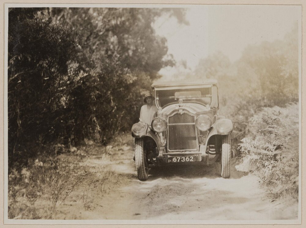 [Woman posed beside motor car]