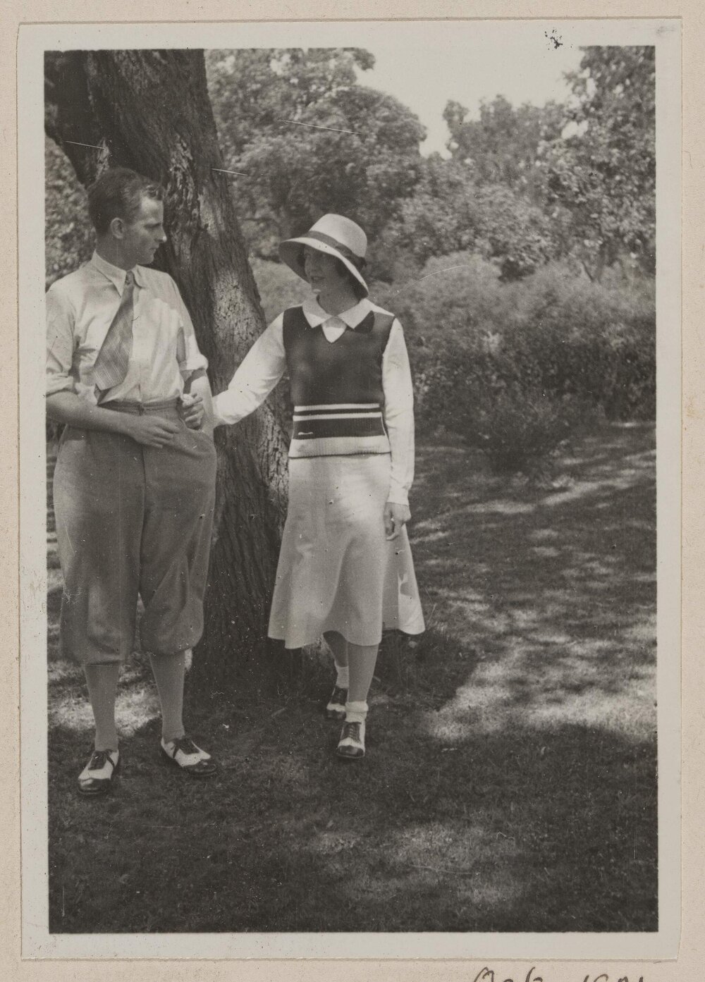 [Man and woman posed next to tree]