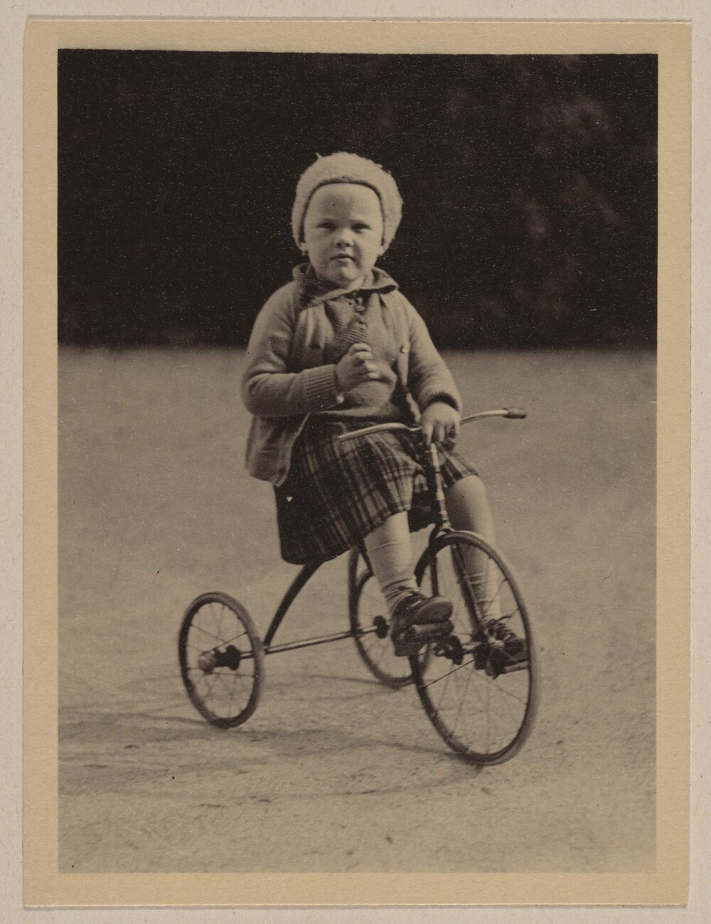 [Small girl riding tricycle]