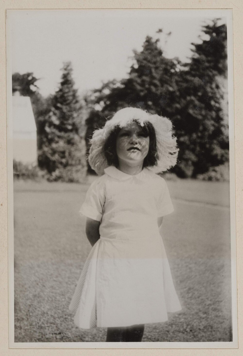 [Young girl posed for wearing hat and dress]