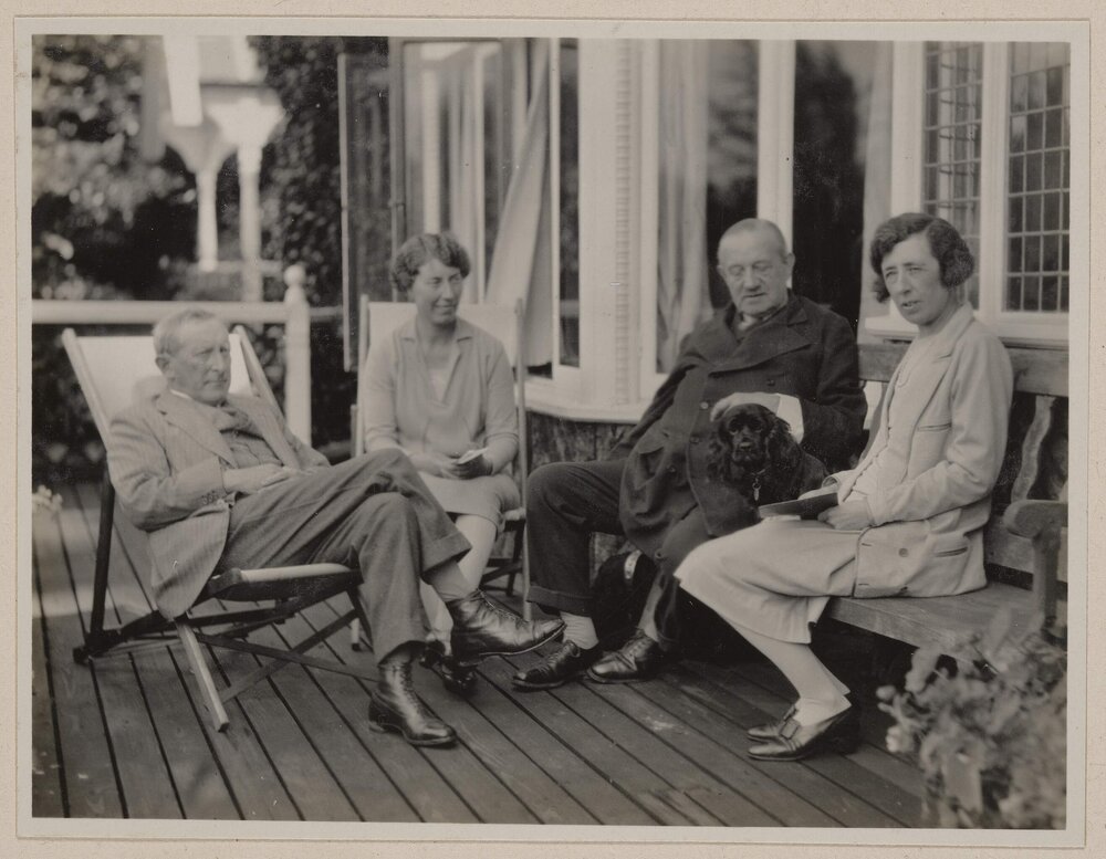 [Two men and two women seated on verandah]