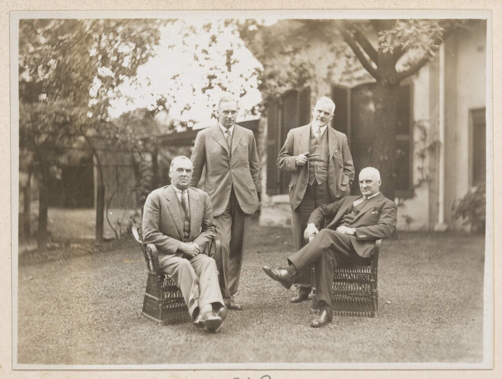 [Group of four men posed on lawn]