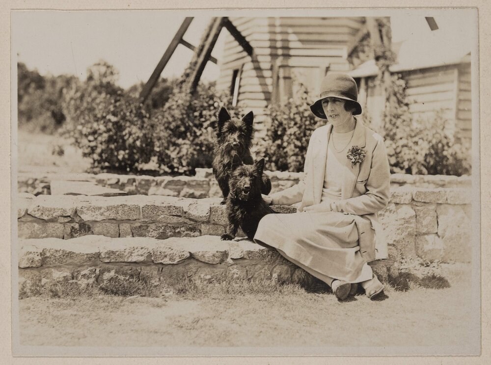 [Mabel seated with dogs on lily pond stone wall] Westerfield]