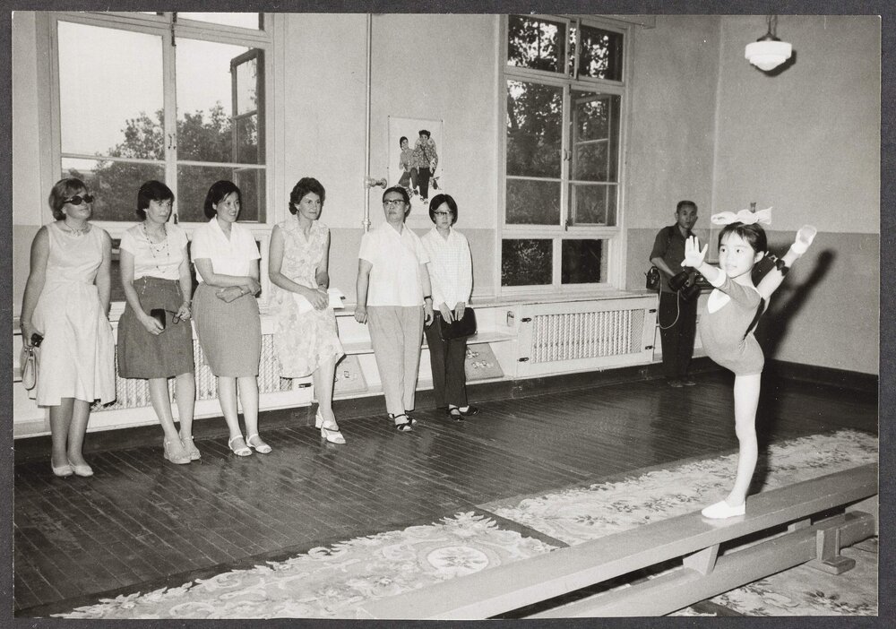 [Tamie Fraser and others watching a gymnastics demonstration]