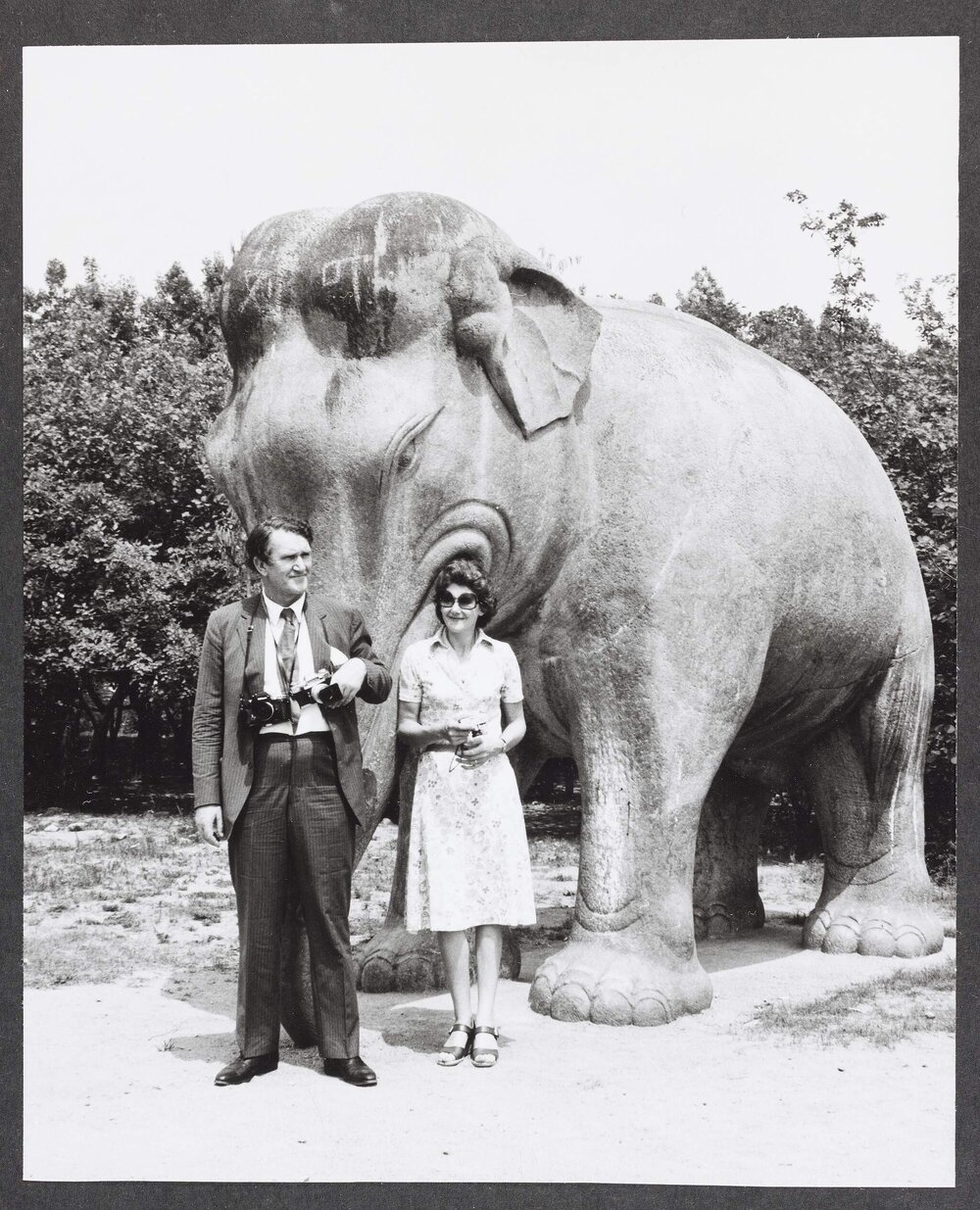 [Malcolm and Tamie Fraser in front of an elephant statue during a visit to China]