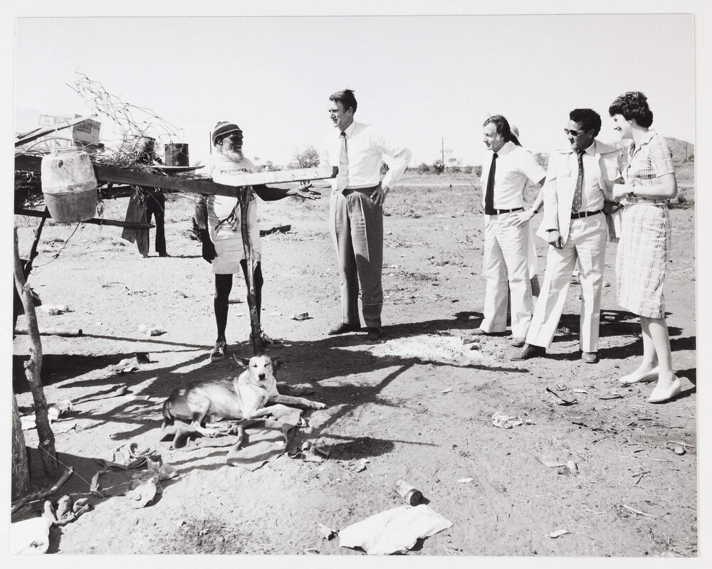 [Malcolm and Tamie Fraser, a group of politicians, and an Aboriginal Australian man believed to be Nosepeg Tjupurrula, during a visit to Papunya]