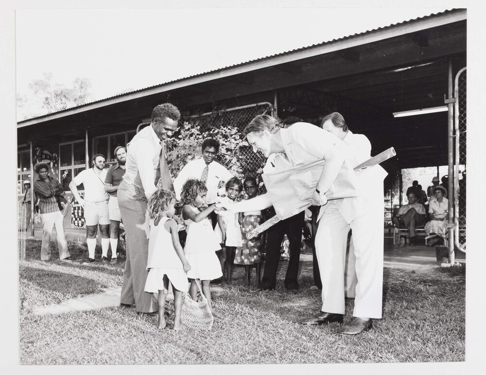 [Malcolm Fraser shaking hands with an unidentified Aboriginal Australian girl during a visit to the Northern Territory]