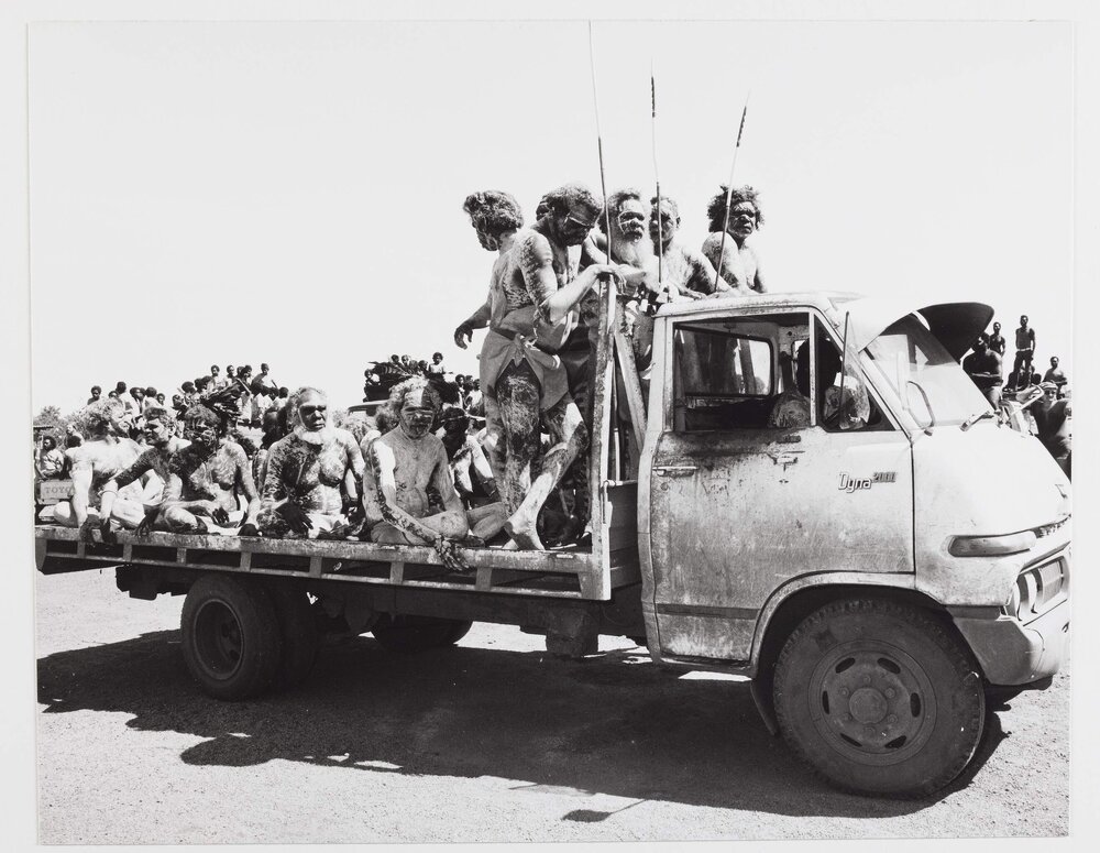 [A group of Aboriginal Australian men in ceremonial painting on the back of a truck]