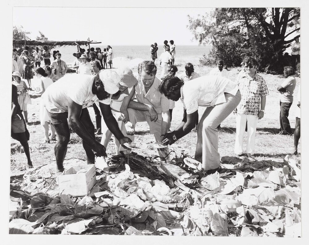 [Malcolm and Tamie Fraser receiving lunch from two unidentified Aboriginal Australian men during a visit to the Northern Territory]