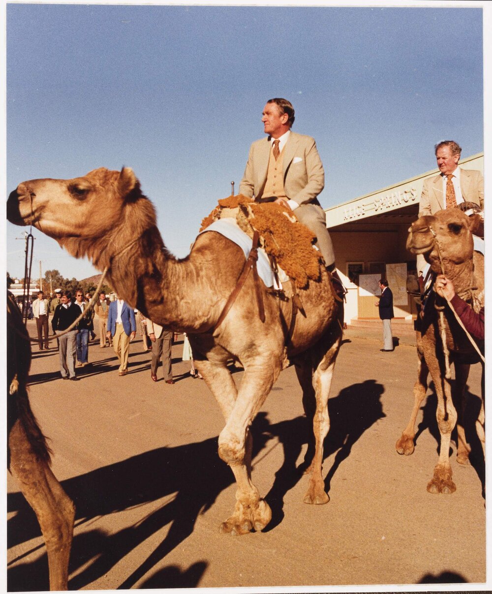 [Malcolm Fraser riding a camel in Alice Springs]