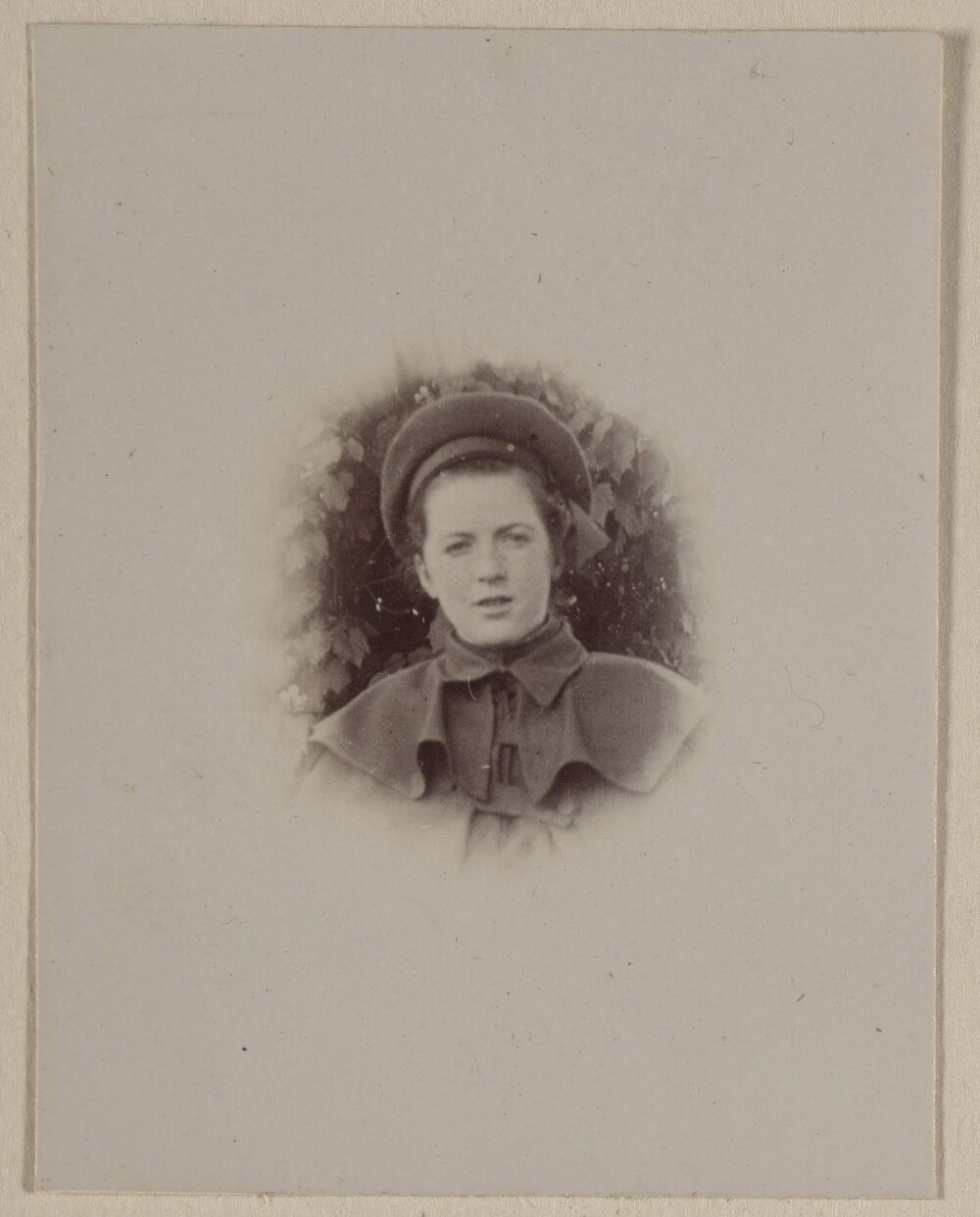 [Woman in collared shoulder cape and hat] 