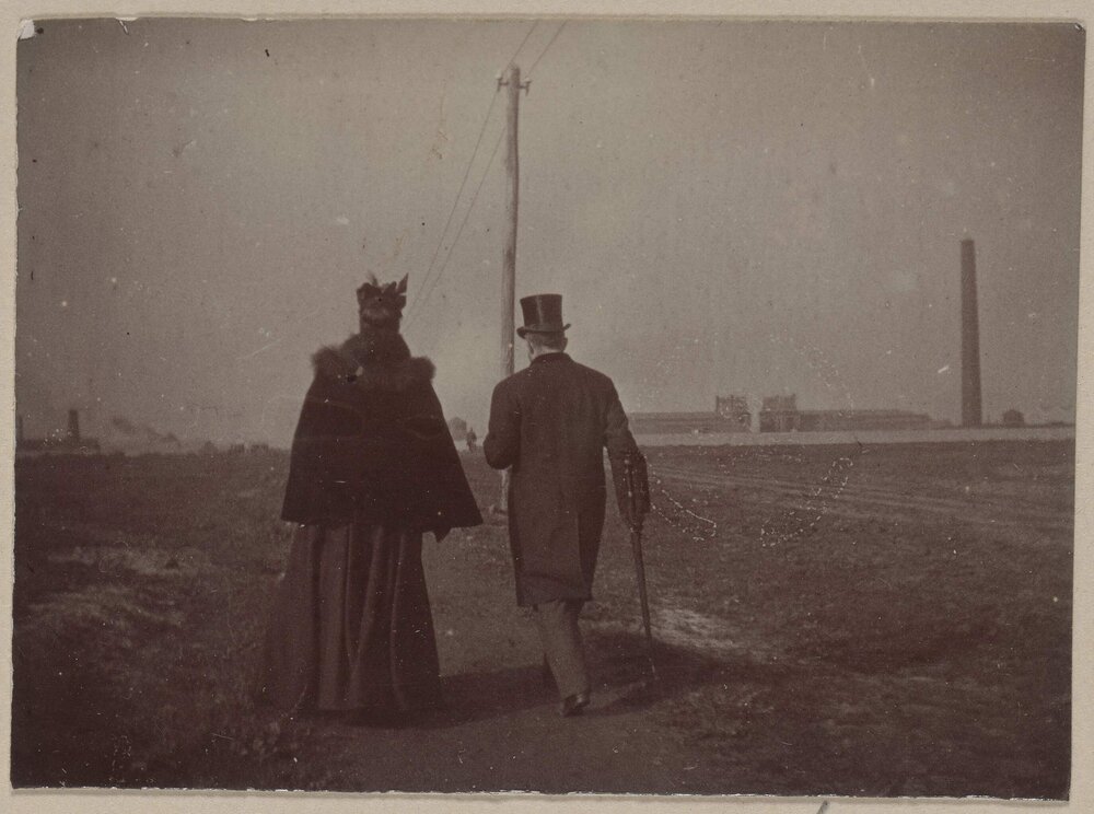 [Woman in cape and man in top hat]