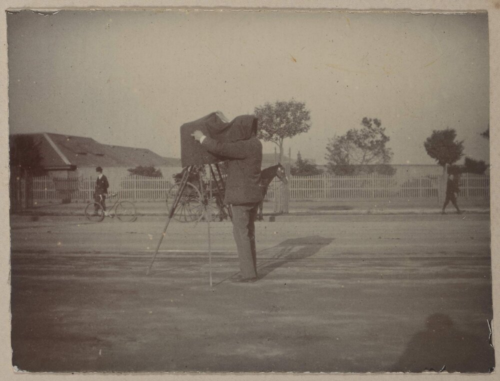 [Man beneath camera focusing hood]