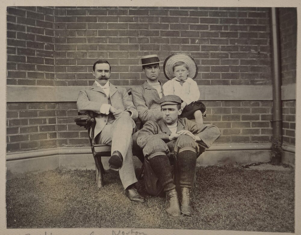 [Three men and one young boy seated together]