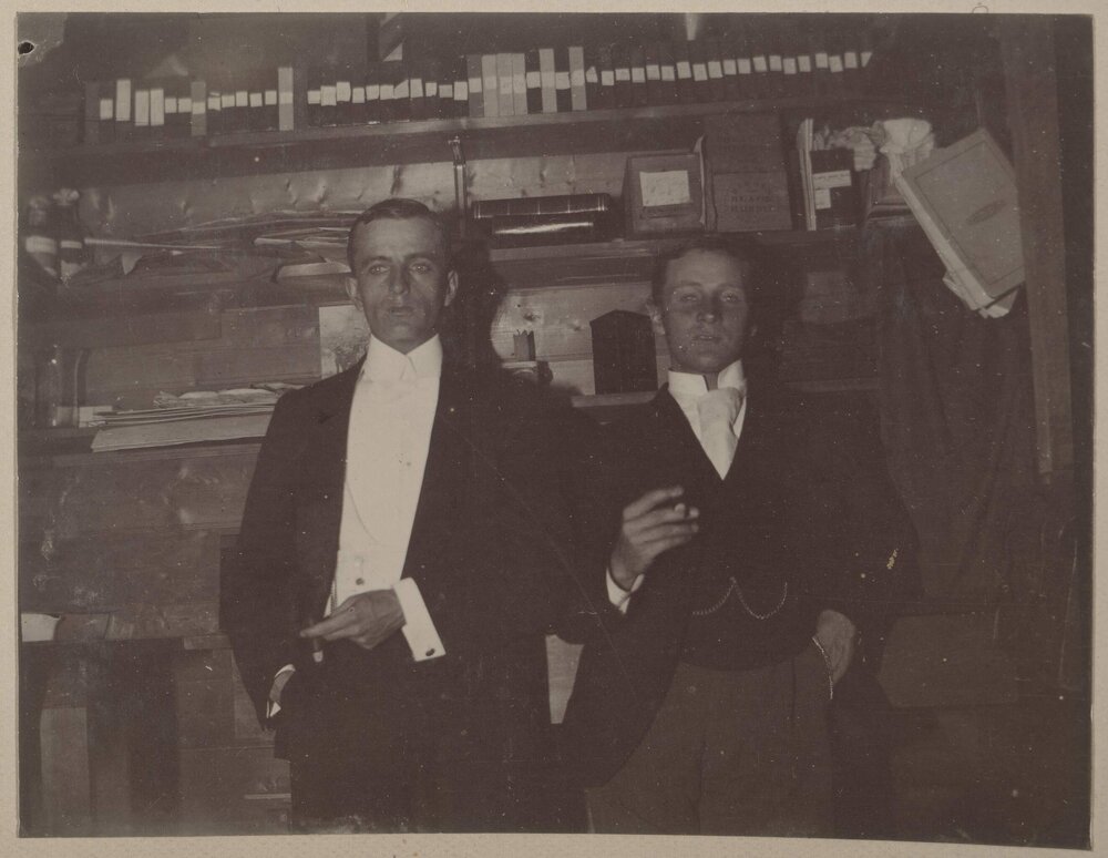 [Two men wearing three piece suits] 