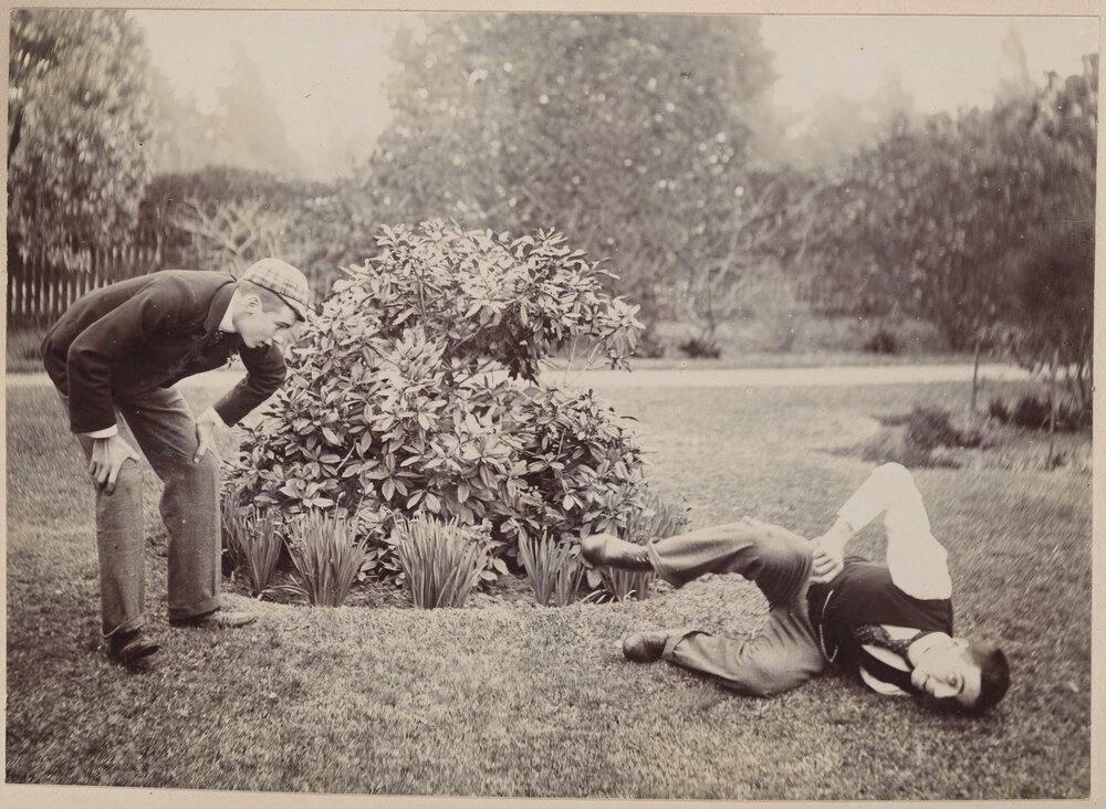 [Man resting hands on knees and man laying on ground]  